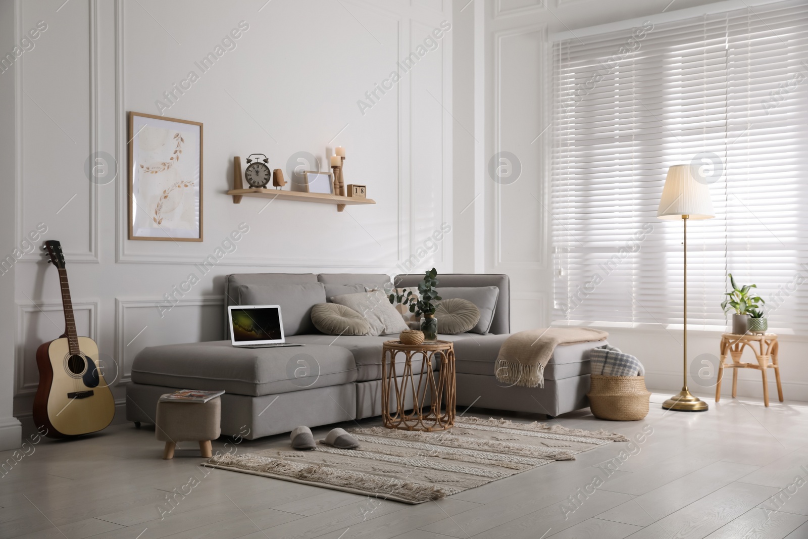 Photo of Living room with comfortable grey sofa and stylish interior elements near window