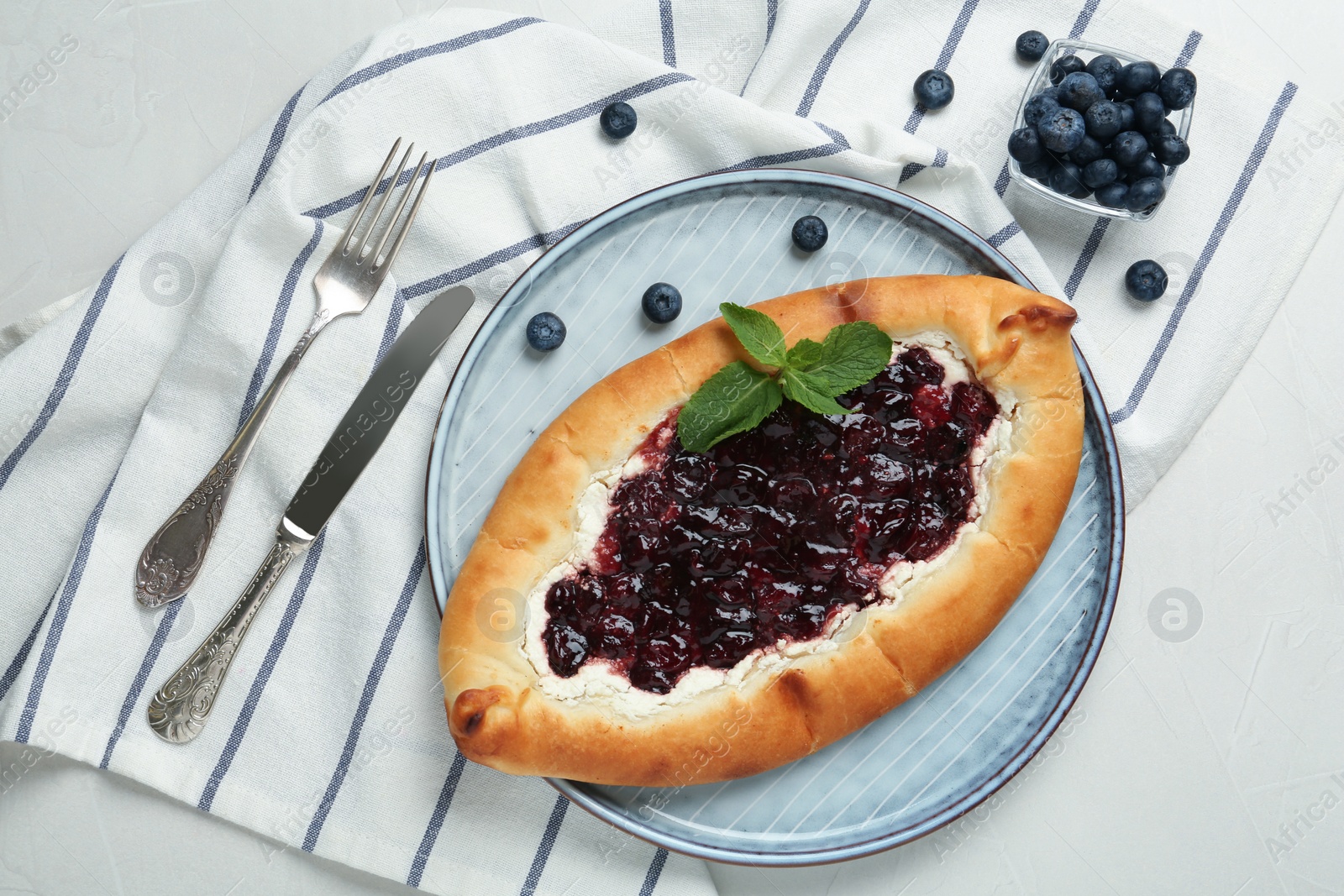 Photo of Delicious sweet cottage cheese pastry with cherry jam served on light table, flat lay