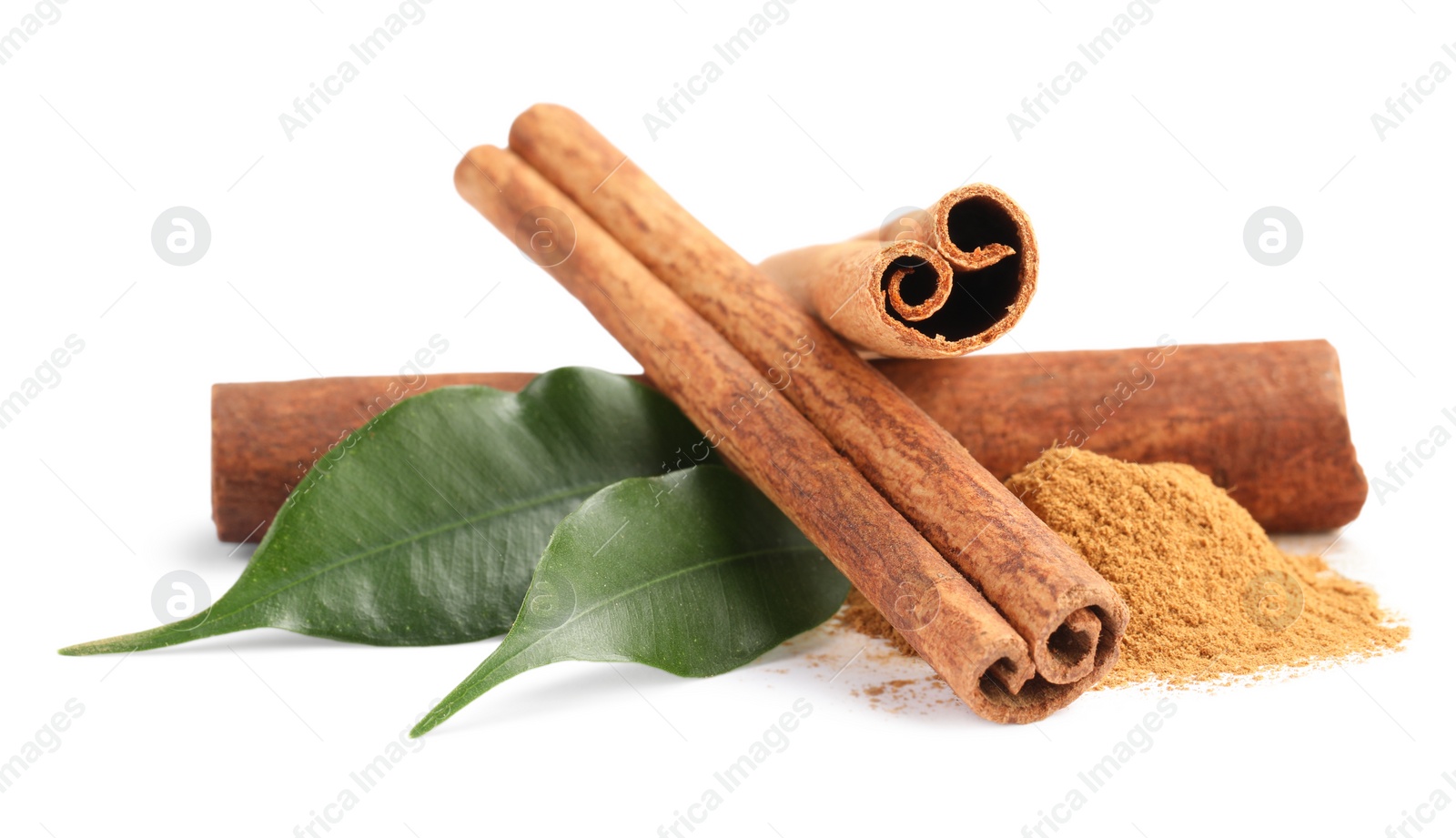 Photo of Dry aromatic cinnamon sticks, powder and green leaves isolated on white