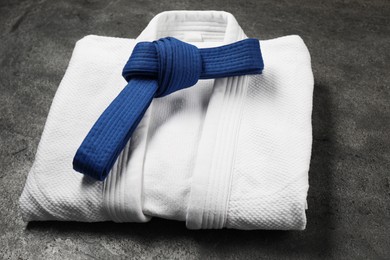 Photo of Blue karate belt and white kimono on gray background