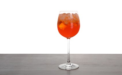 Photo of Aperol spritz cocktail and ice cubes in glass on wooden table against white background