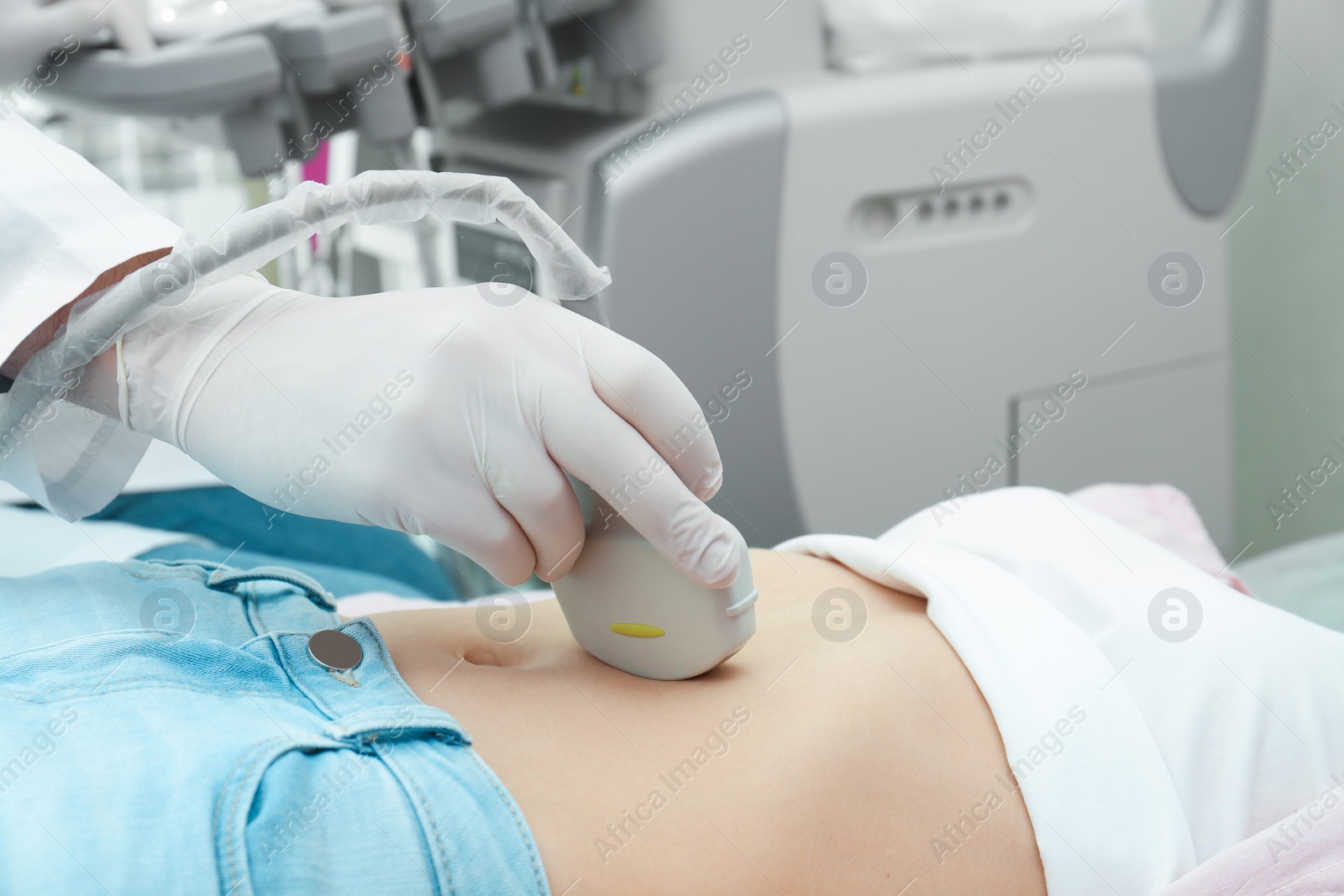 Photo of Doctor conducting ultrasound examination of internal organs in clinic, closeup