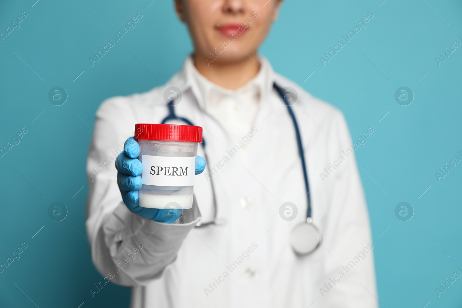 Photo of Doctor holding container with sperm on turquoise background, closeup. Space for text