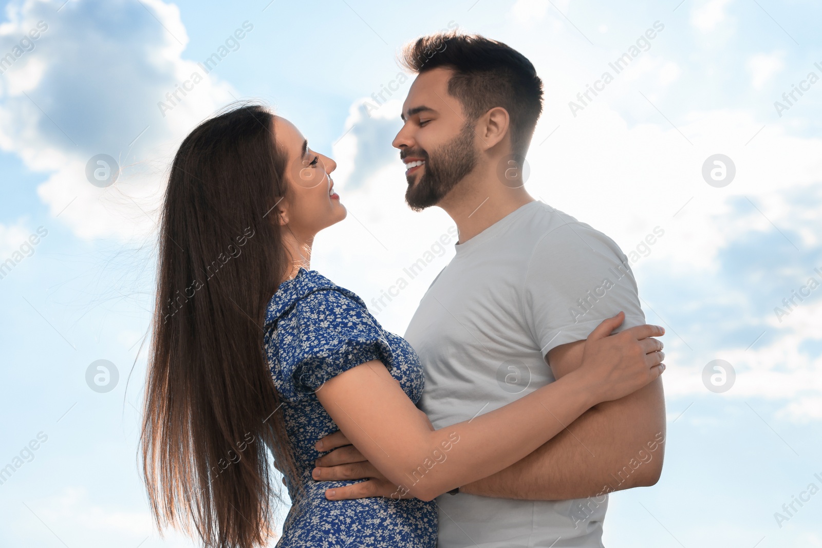 Photo of Romantic date. Beautiful couple spending time together against blue sky