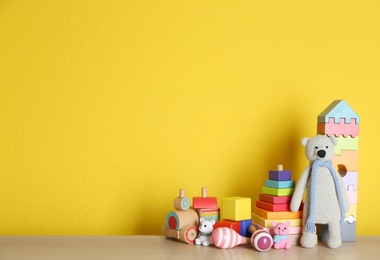 Photo of Set of different toys on wooden table. Space for text