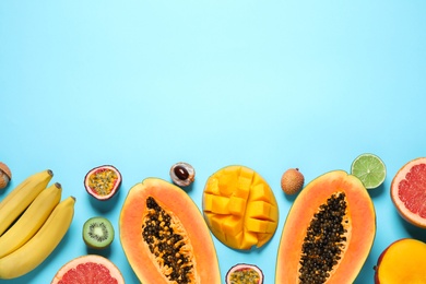 Photo of Fresh ripe papaya and other fruits on light blue background, flat lay. Space for text