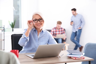 Photo of Businesswoman with colleagues working in office, space for text. Professional communication