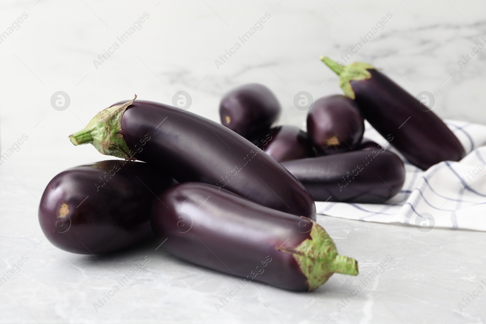 Photo of Many raw ripe eggplants on grey table