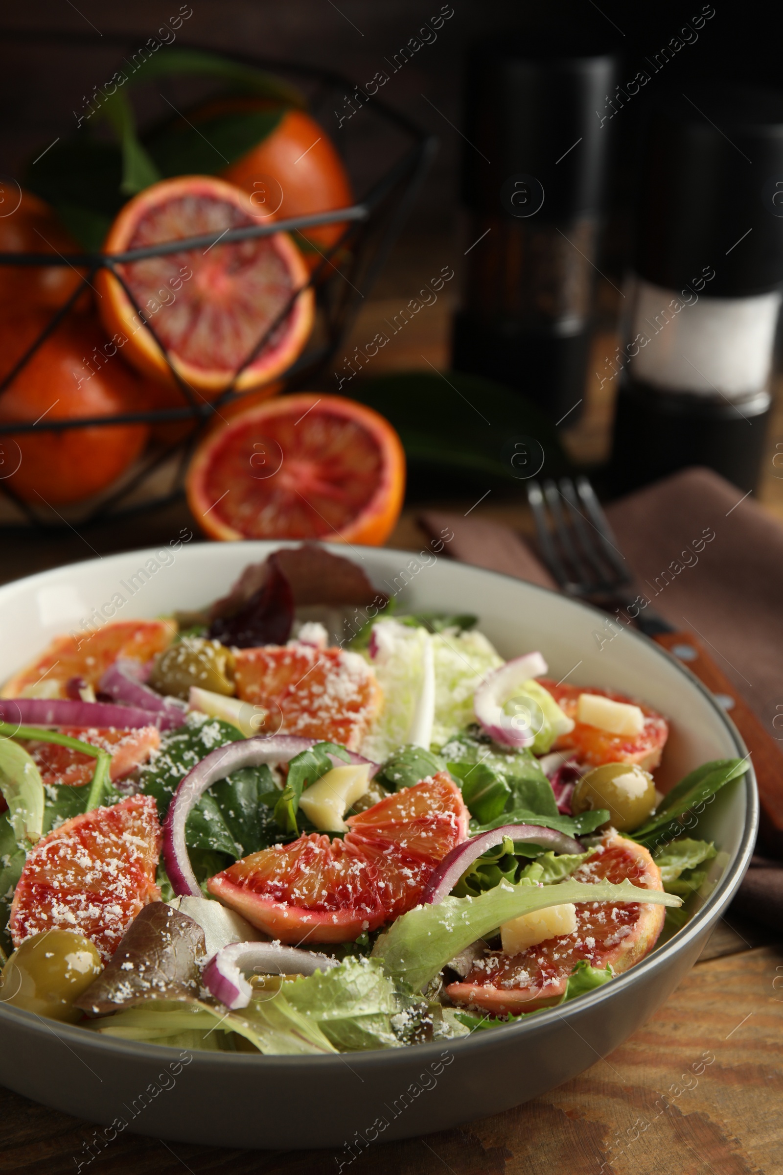 Photo of Bowl of delicious sicilian orange salad on wooden table, closeup. Space for text