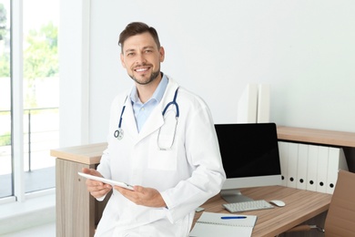 Photo of Male medical assistant near workplace in clinic. Health care service