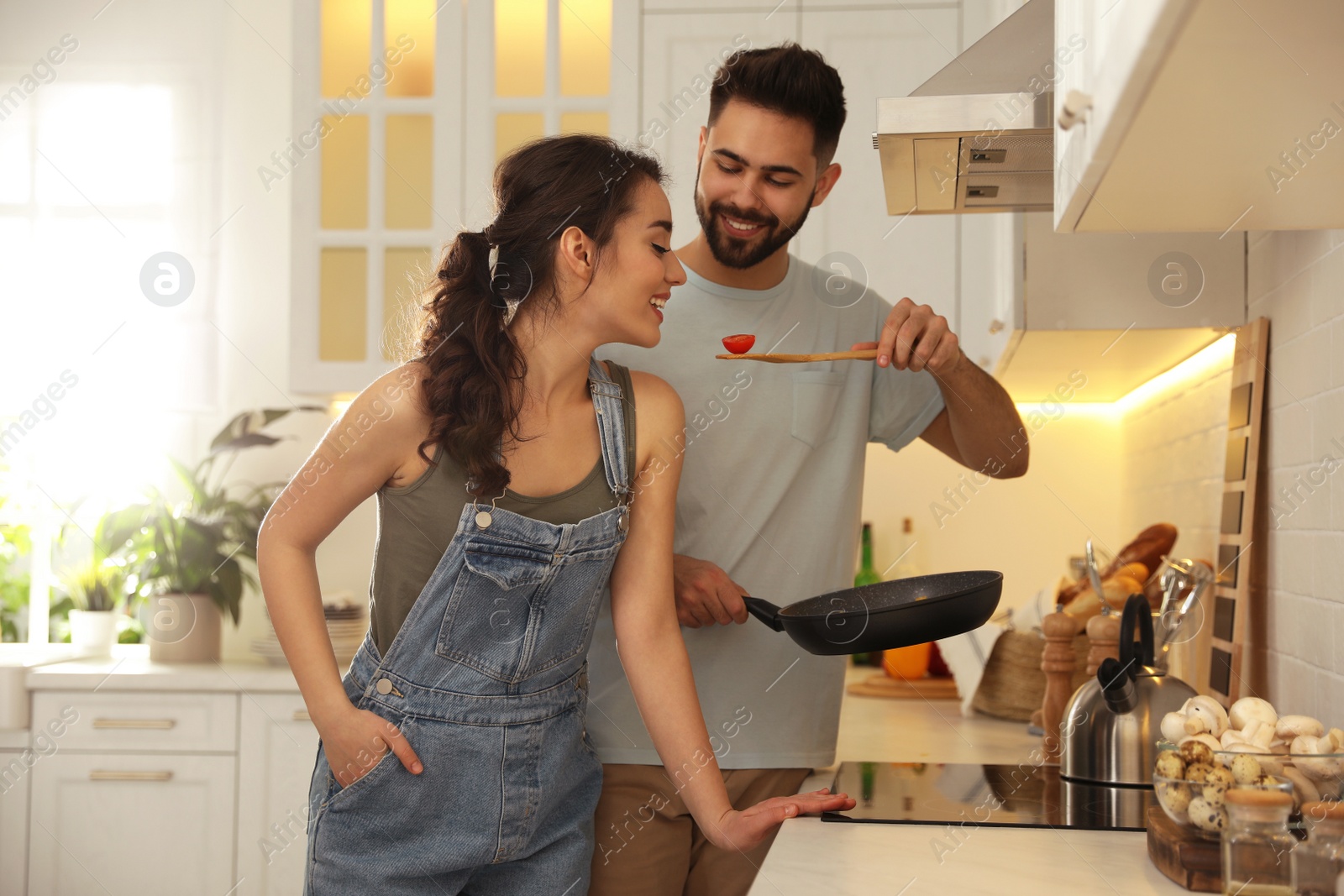 Photo of Lovely young couple cooking together in kitchen