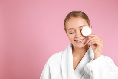 Photo of Beautiful young woman with cotton pad on pink background. Space for text