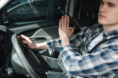 Driver refusing from alcohol while woman suggesting him beer in car, closeup. Don't drink and drive concept