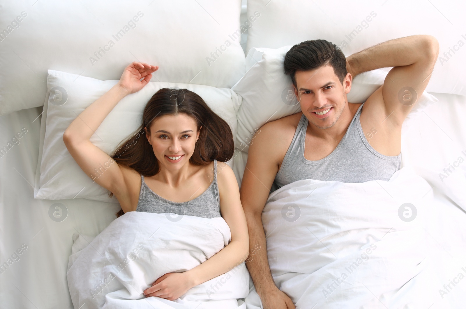 Photo of Lovely young couple resting in large bed, above view