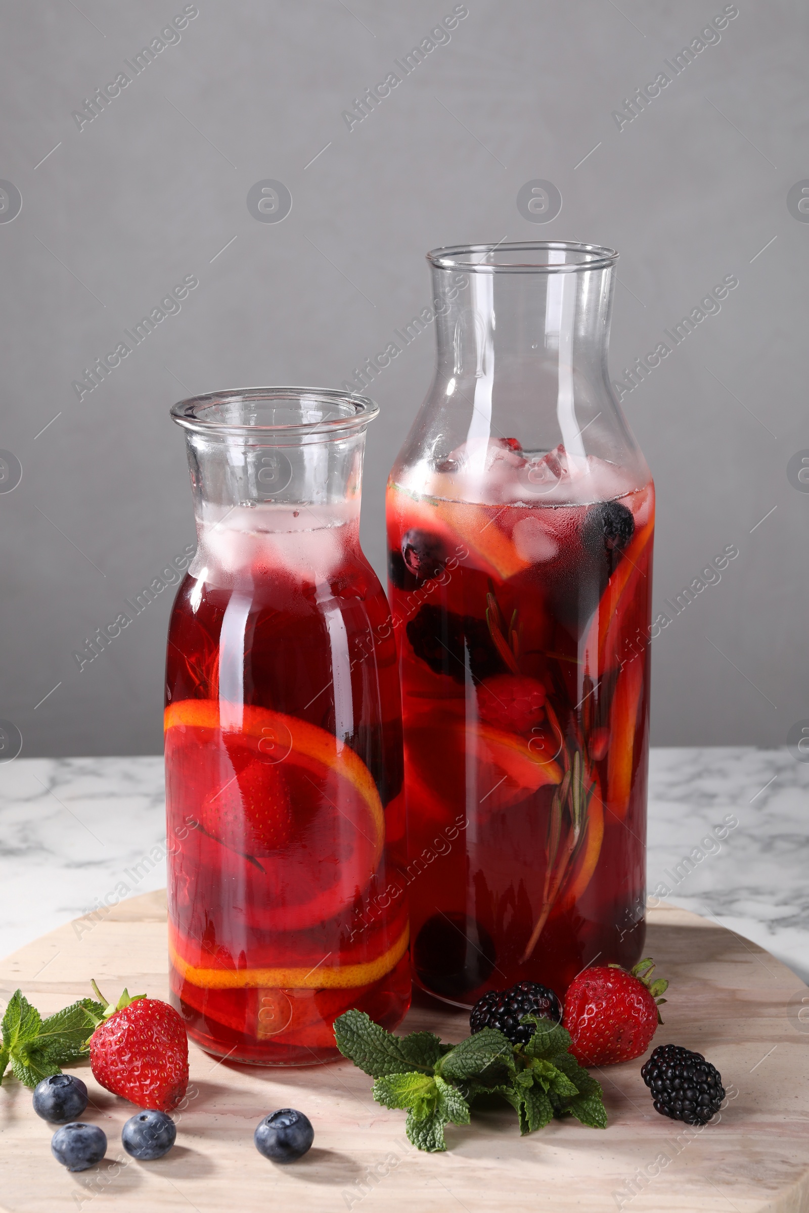 Photo of Delicious refreshing sangria and berries on white marble table