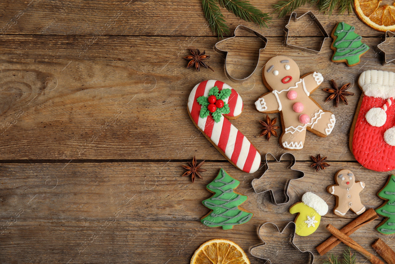 Photo of Flat lay composition with Christmas biscuits and cookie cutters on wooden table. Space for text.