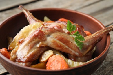 Photo of Tasty cooked rabbit with vegetables in bowl on table, closeup
