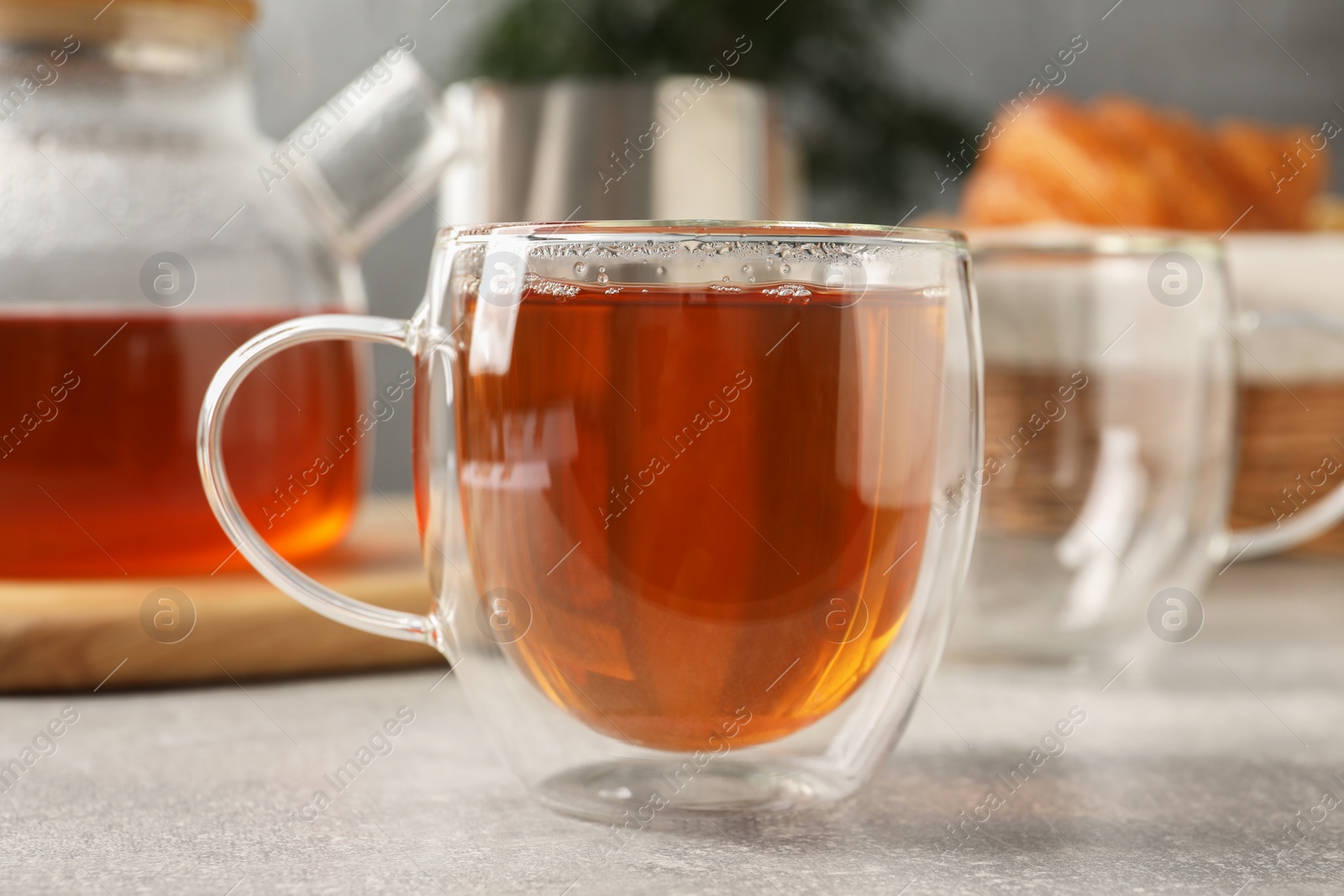 Photo of Aromatic tea in glass cup on light grey table