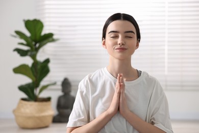 Portrait of beautiful girl meditating in yoga studio