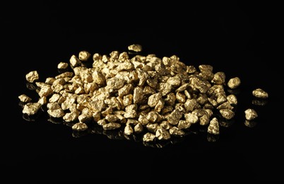 Photo of Pile of gold nuggets on black background