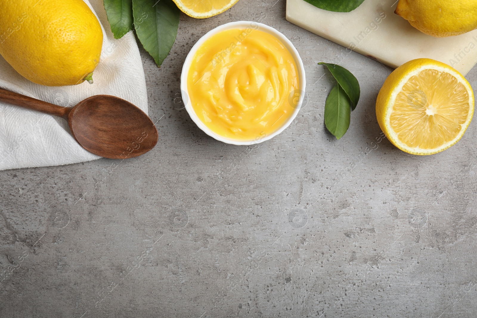 Photo of Delicious lemon curd in bowl on grey table, flat lay. Space for text