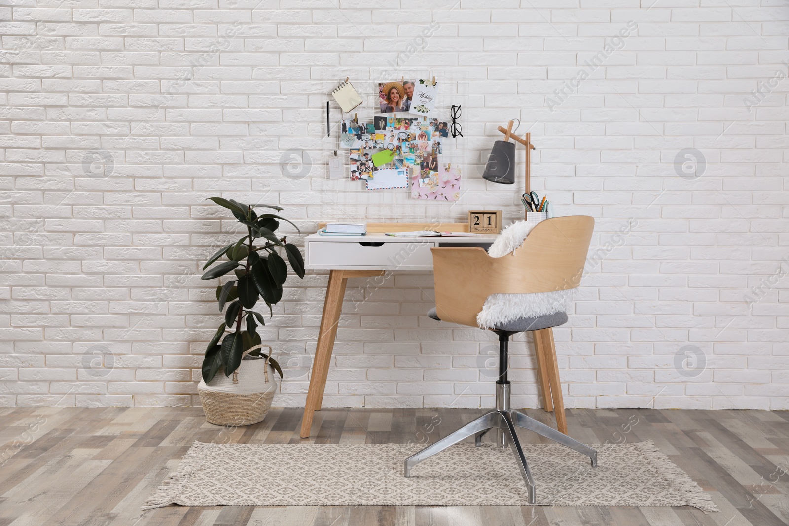 Photo of Stylish room interior with workplace and vision board