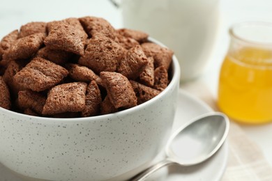 Photo of Bowl of sweet crispy chocolate corn pads on table, closeup