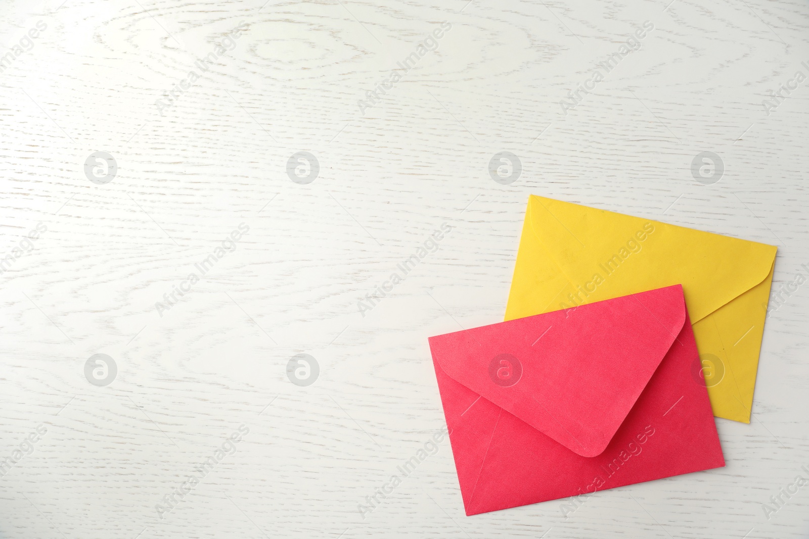 Photo of Paper envelopes on white wooden background, flat lay. Space for text