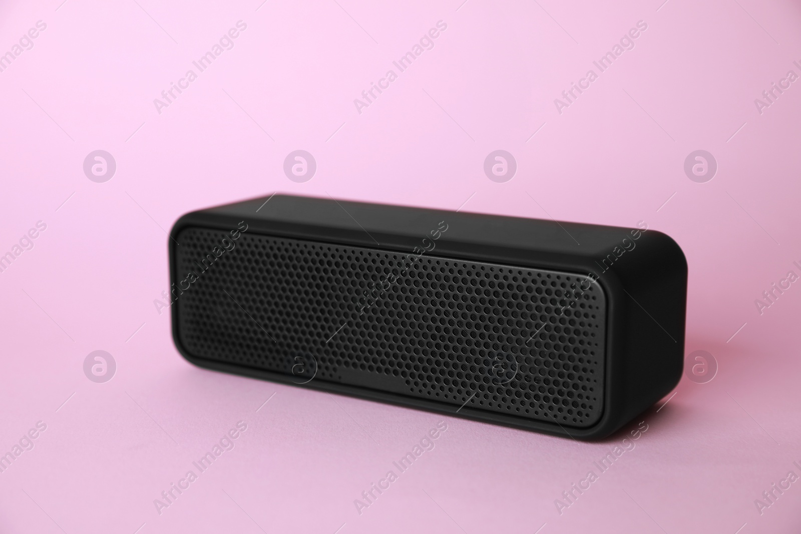 Photo of One portable bluetooth speaker on pink background. Audio equipment