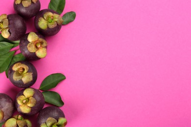 Photo of Fresh ripe mangosteen fruits with green leaves on pink background, flat lay. Space for text