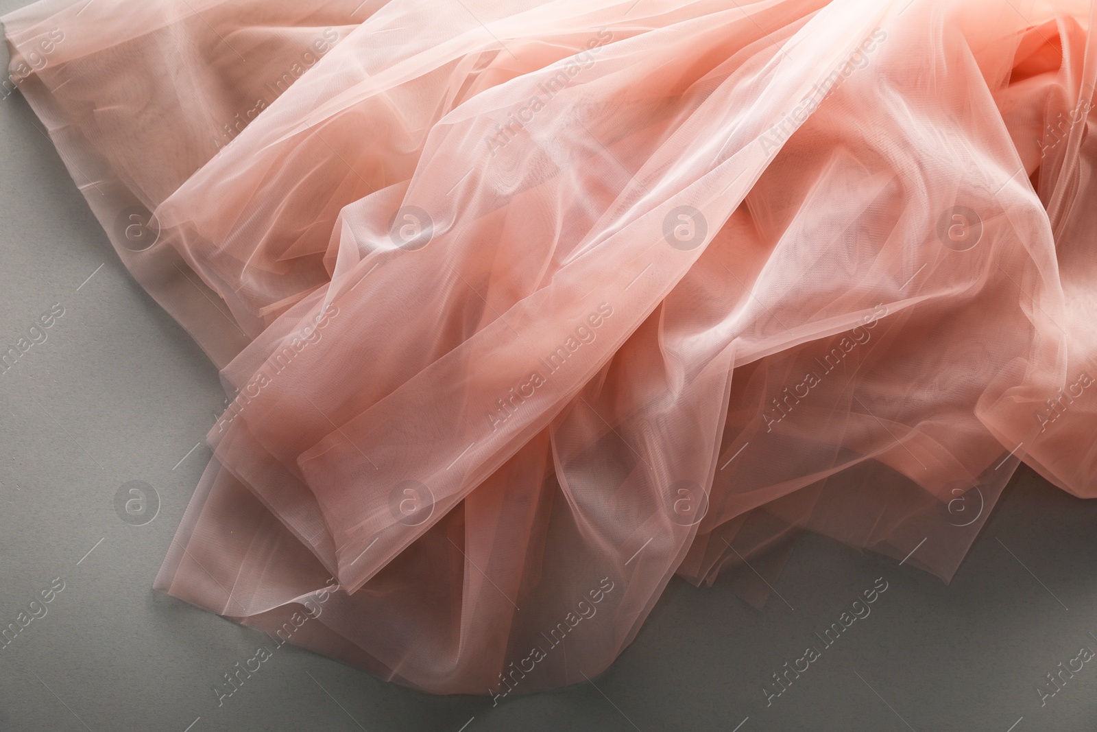 Photo of Beautiful tulle fabric on grey background, top view