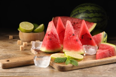 Photo of Tasty juicy watermelon, ice and lime slices on wooden table