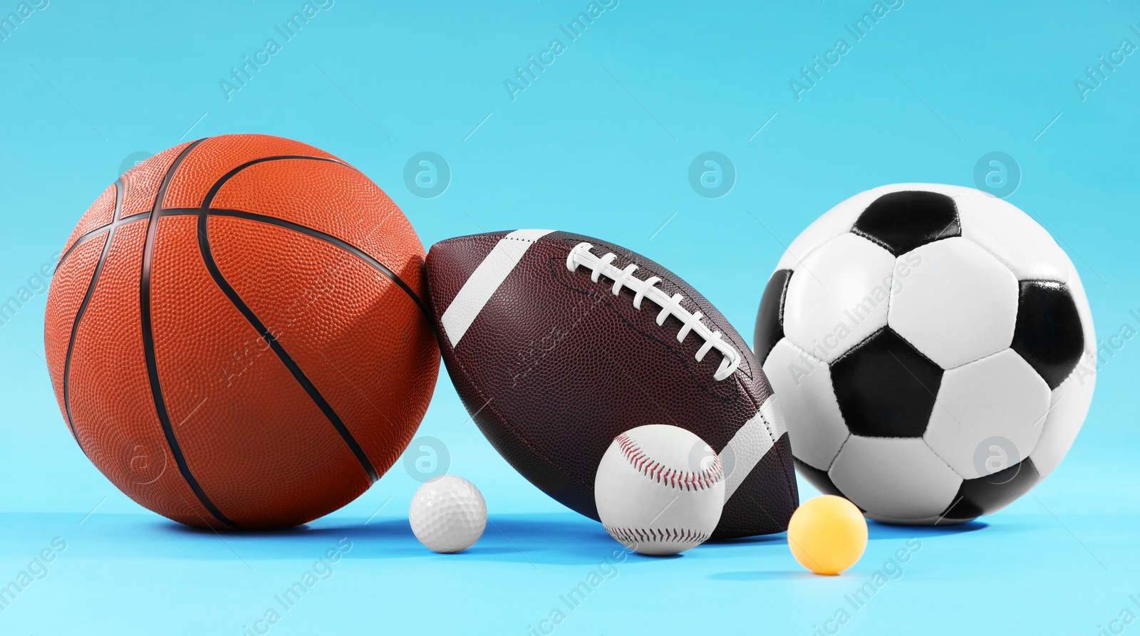 Photo of Many different sports balls on light blue background
