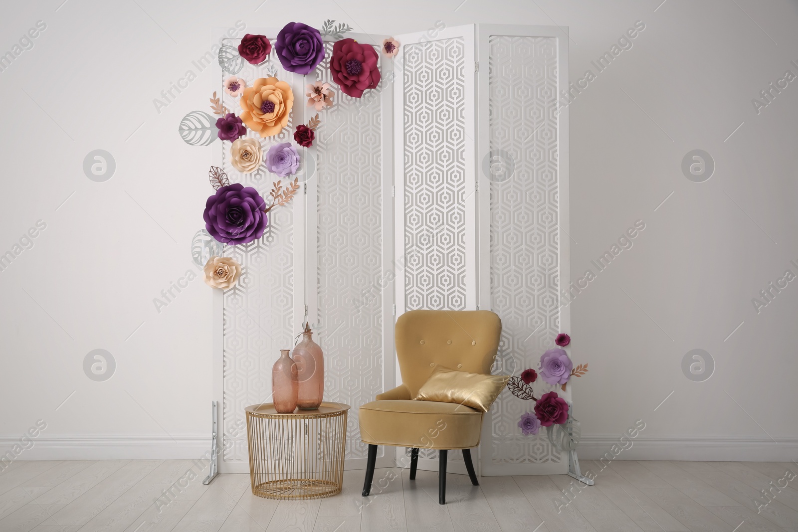 Photo of Beautiful photo zone with folding screen, chair and floral decor indoors