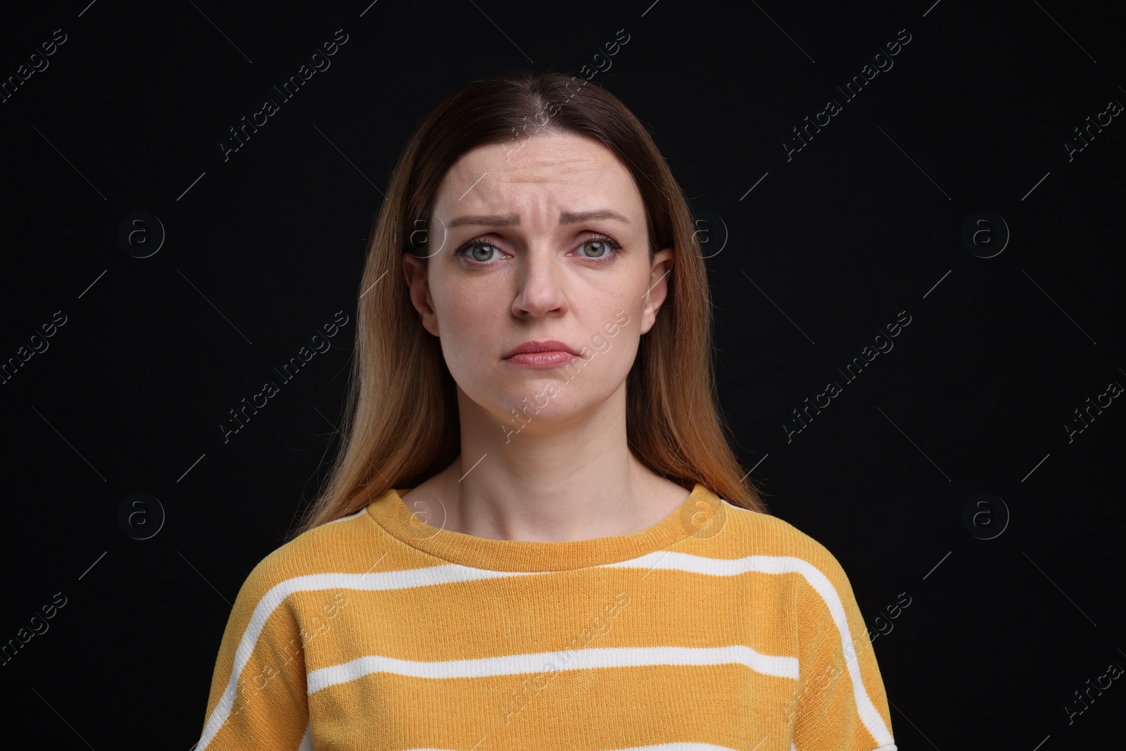 Photo of Portrait of sad woman on black background