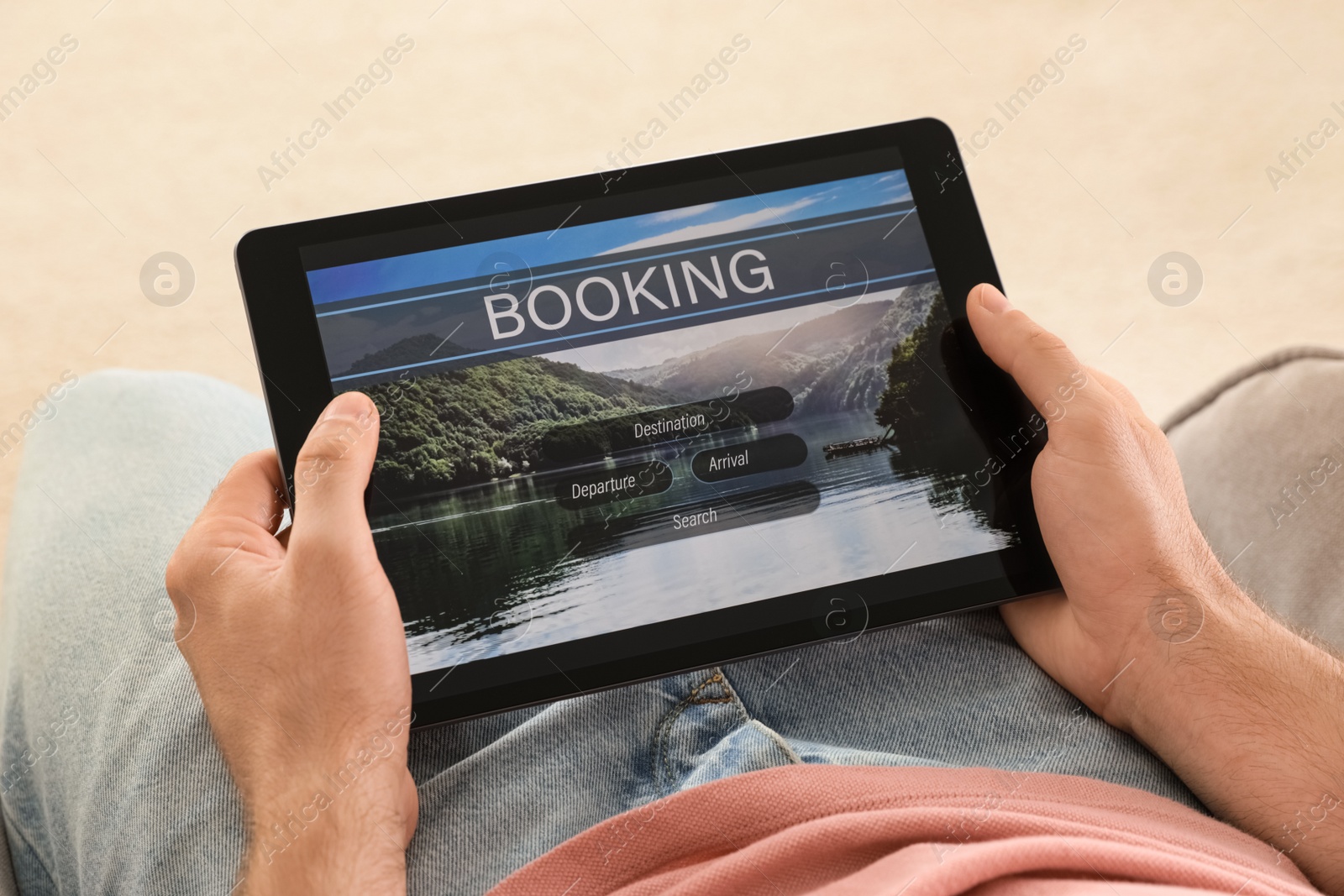 Photo of Man booking tickets online on sofa indoors, closeup. Travel agency concept