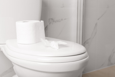Photo of New paper roll on toilet bowl in bathroom