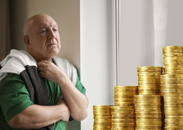 Image of Pension plan. Elderly man and stacks of coins in room