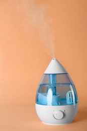 Photo of New modern air humidifier on orange background
