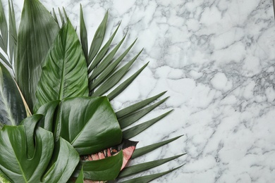 Photo of Flat lay composition with tropical leaves and space for text on marble background