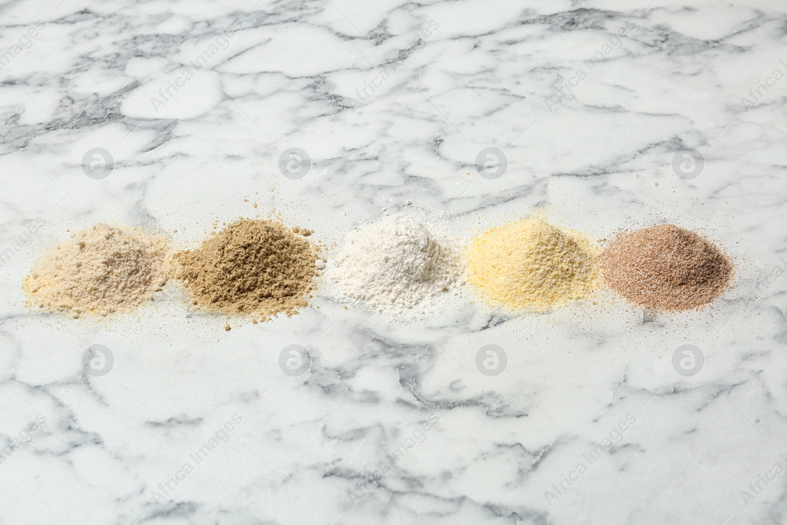 Photo of Piles of different flour types on marble table