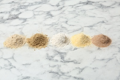 Photo of Piles of different flour types on marble table