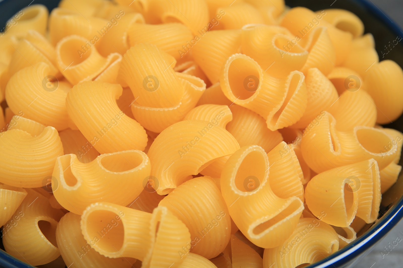 Photo of Raw macaroni pasta in bowl, closeup view