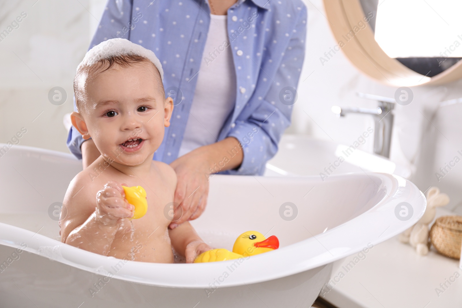 Photo of Mother with her little baby in bathroom