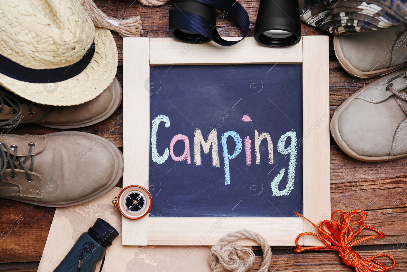 Photo of Flat lay composition with camping equipment on wooden background