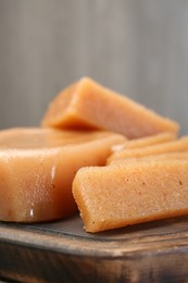 Photo of Tasty sweet quince paste on wooden board, closeup