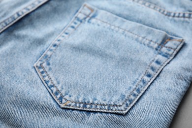 Photo of Jeans with pocket on grey background, closeup