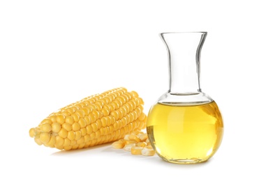 Photo of Jug with fresh corn oil and fresh cob on white background