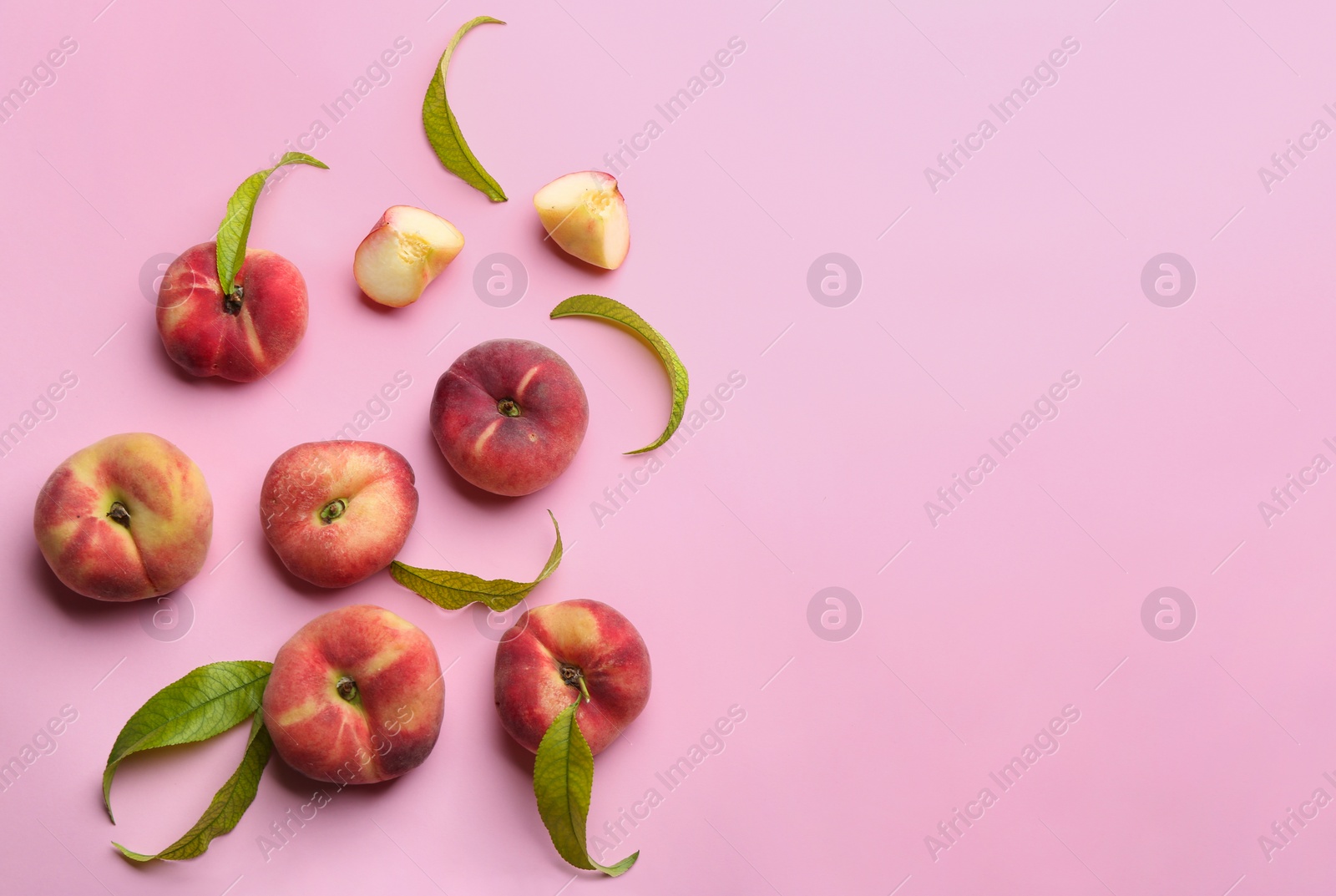 Photo of Fresh donut peaches on light pink background, flat lay. Space for text