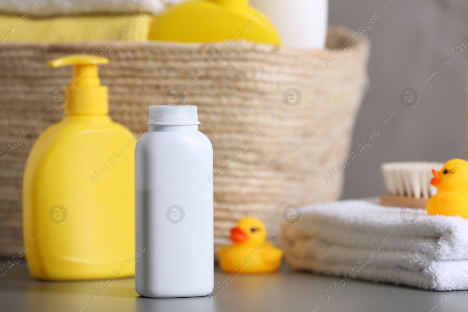 Photo of Baby cosmetic products, towel and rubber ducks on grey table, space for text